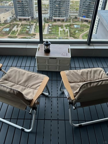 Small balcony garden with compact furniture, green plants, and warm decor for comfortable outdoor li