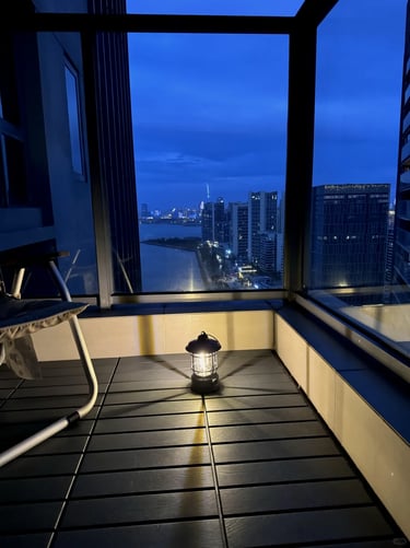 Small balcony garden with compact furniture, green plants, and warm decor for comfortable outdoor li