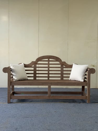 Classic wooden bench with soft cushions, designed as a quiet outdoor seat for relaxed garden living.
