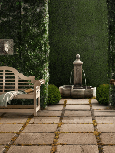 Wooden garden bench facing a formal garden path and fountain, creating a calm and well-placed seatin