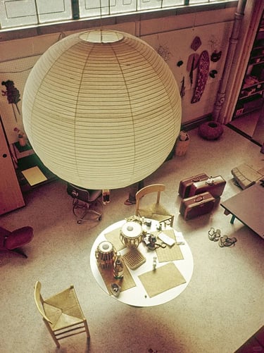 Large round Akari paper lamp illuminating a living space with soft warm light and sculptural presenc