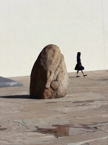 Natural rock sculpture in Noguchi Garden, surrounded by stone paving and quiet open space
