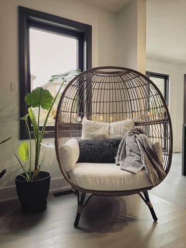 Cozy hanging lounge chair with soft cushions, warm lighting and natural textures for relaxed outdoor