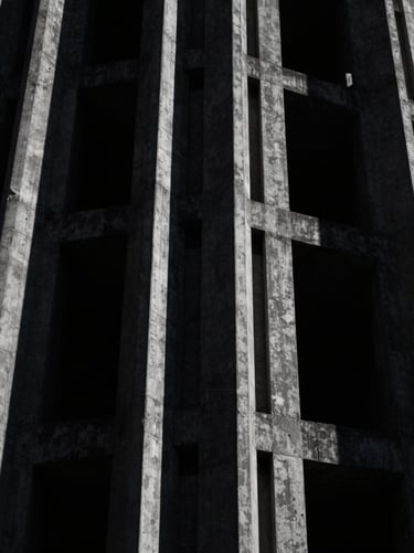 High-contrast desaturated manga panel crop, showing towering futuristic concrete megastructures under harsh shadow, dark cinematic photography