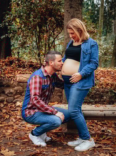 pareja dando un beso en la barriga embarazada de la madre