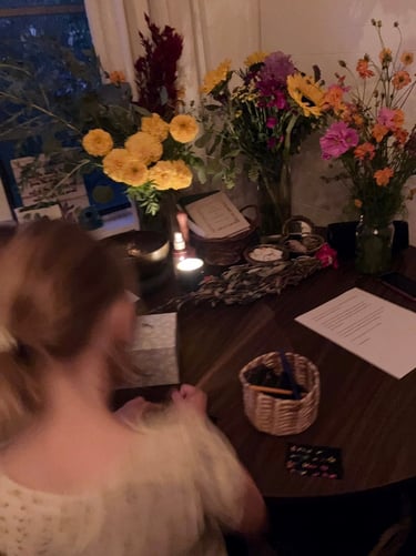 A young girl writing at a table with a home funeral altar.