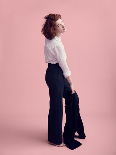 A woman wearing a white shirt and dark pants.