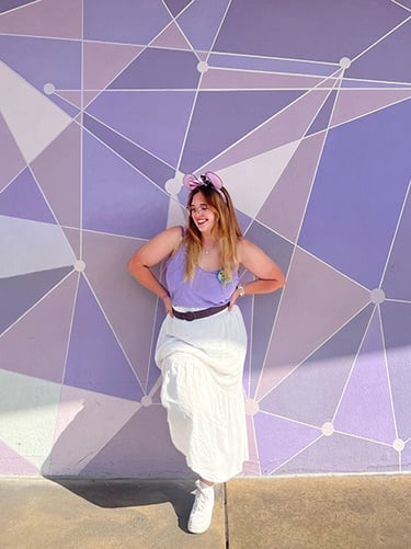 Ameliah Knopp pictured in front of the Purple Wall at Disney's Magic Kingdom® Park.