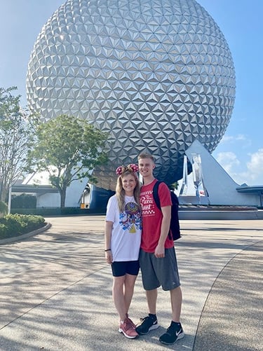 Kasey Kalk pictured with her husband in front of Spaceship Earth at EPCOT®.