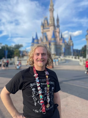 Minnie's Travel Boutique travel advisor Zach Stout pictured in front of Cinderella Castle at Disney's Magic Kingdom® Park.