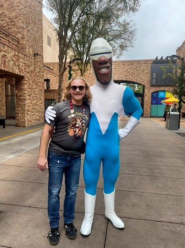 Minnie's Travel Boutique travel advisor Zach Stout pictured with Frozone inside Disney's Hollywood Studios® Park.
