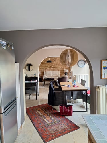 Cuisine avant transformation montrant une vue ouverte avec une arcade vers le salon