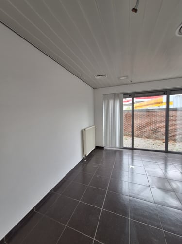 Image d'une des pièces du showroom avec une grande baie vitrée et un radiateur