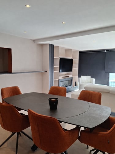 Table de salle à manger avec chaises terracotta dans un séjour beige et noir