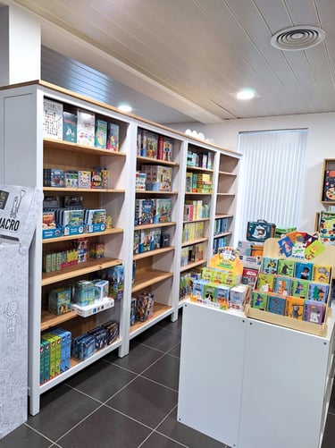 Aménagement du magasin de jouets avec des étagères blanches et un plan de travail comme présentoir