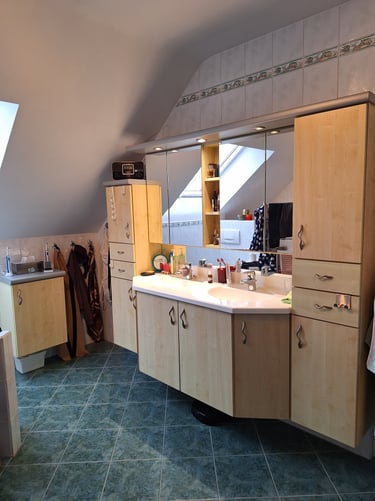 Salle de bain avant rénovation avec un meuble suspendu sur-mesure et deux grands miroirs