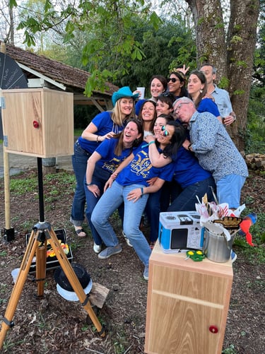 A group of friends posing for a fun outdoor photo booth with props at a birthday party celebration.