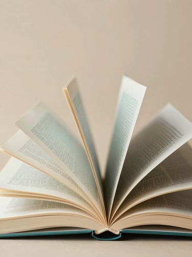 A creative arrangement of open books where the pages are fanned out artistically, set against a warm sandy background #D4B281. The book covers feature muted teal #7A9E9F and charcoal #3D3B3C tones.