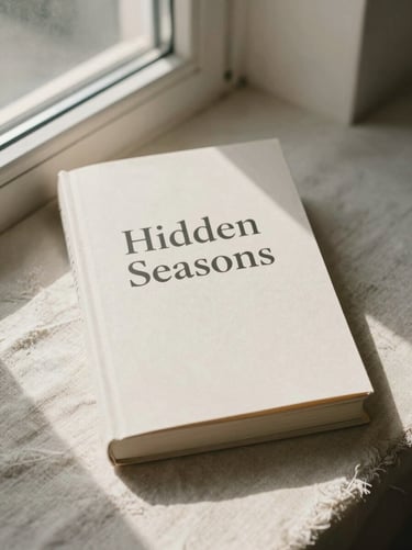 Book cover of Hidden Seasons resting on natural linen, soft morning window light, muted earth tones.