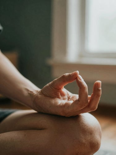 Unposed close-up of hands in a mudra gesture during quiet meditation, soft morning light, warm organic textures.