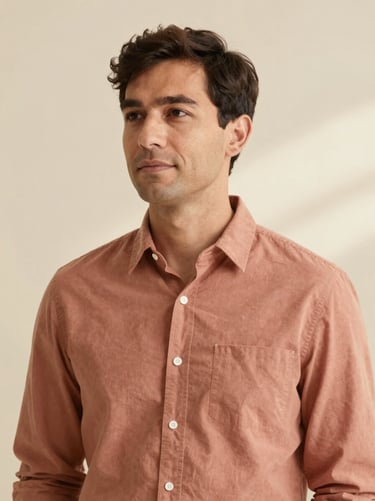 Editorial studio portrait of a male brand strategist, neutral warm cream background, soft natural side light, 35mm photography