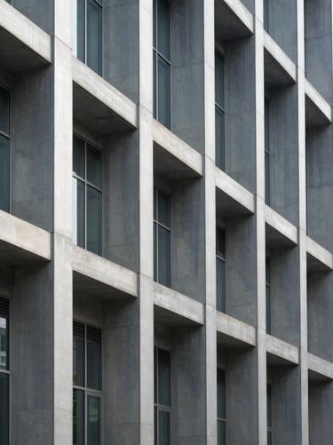 Clean architectural detail of structural steel columns and glass facade, sharp daylight, projecting stability and institutional scale.