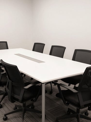 A wide shot of a professional North American / US creative agency meeting room with jet black chairs and a large white table, captured in clean, bright photography style.