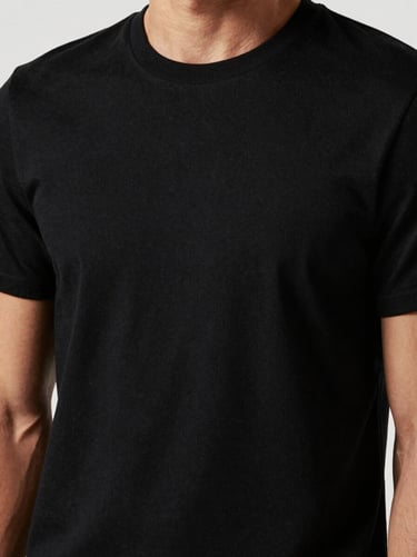 Close-up of a premium black t-shirt on a model, high-contrast studio lighting, showcasing fabric texture and clean stitching, 85mm lens