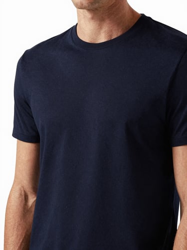Close-up of a premium navy blue t-shirt on a model, high-contrast studio lighting, clean masculine tailoring, 85mm lens