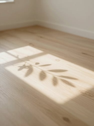 Soft sunlight casting gentle leaf shadows on a clean, empty treatment room floor with light wood textures.