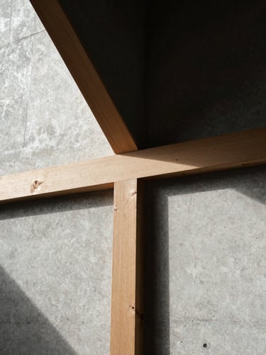 Abstract macro detail of a hand-carved wood joint meeting a polished concrete wall, sharp chiaroscuro lighting.