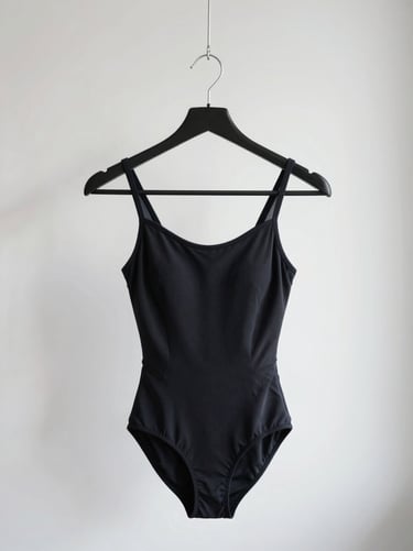 Minimalist leotard on a black steel hanger against a stark white background, soft diffused side-lighting