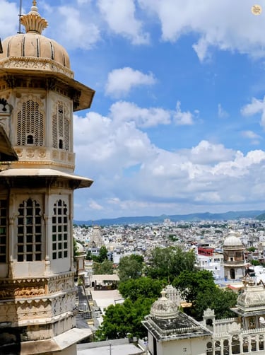 High viewpoint shot of Udaipur from Badi Mahal, including the City Palace tower and surrounding town.