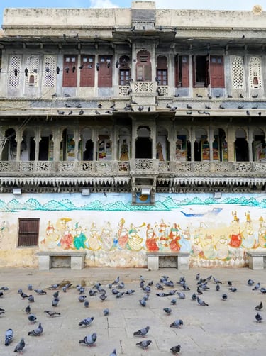 Lakeside steps of Gangaur Ghat with pigeons flying and havelis behind, udaipur Rajasthan.
