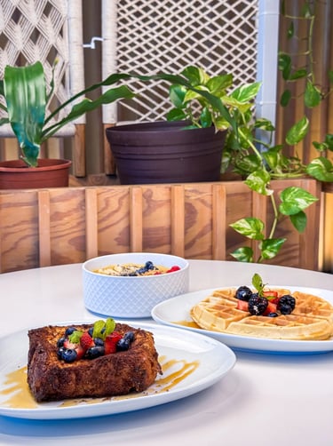 a table with a plate of food and a bowl of fruit