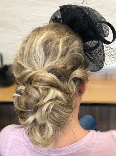 a woman with a veiled headpiece on her head displaying hairstyling for a wedding