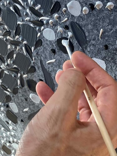 Close-up of Adib Haddad’s hand painting textured black and white mosaic patterns on canvas