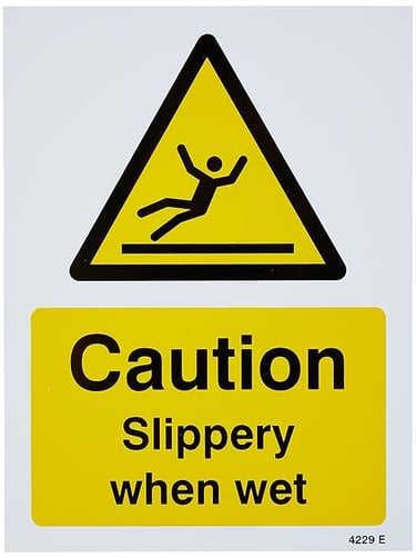 Yellow and black Caution Slippery When Wet safety sign with a falling person icon.