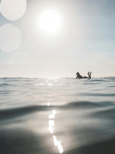 a person laying on a surfboard in the ocean