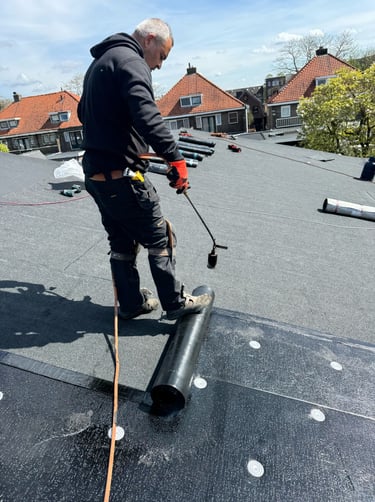 Dakdekker aan het werk op een plat dak in Almere