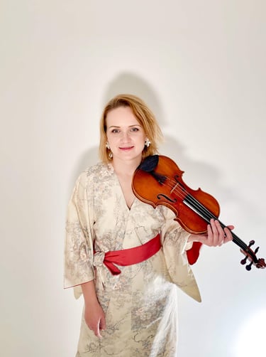 Lithuanian violinist Žydrė wearing a kimono-inspired dress, holding a violin in a studio portrait