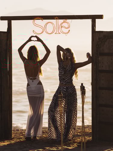 Elegant guests arriving at the iconic SOLÉ wooden gate, Trocadero Zanzibar Marbella beachfront.