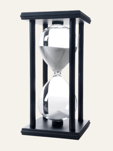 picture of an hourglass in a black fixture with white sand