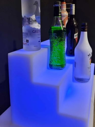 Blue glow drink stand with bottles of alcohol, accessory to glow bar in Redlands.