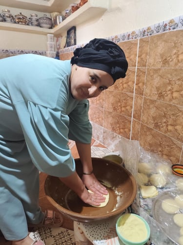 a woman in a blue shirt is holding a bowl of doughnuts