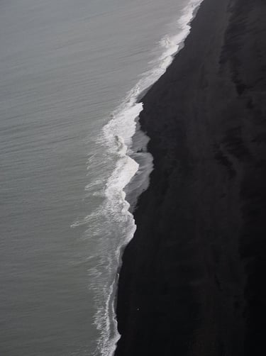 a person walking along a beach with a surfboard