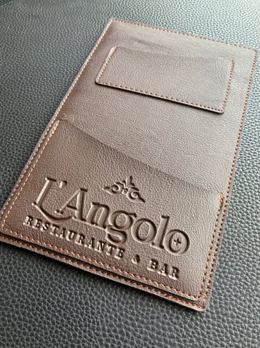 Fotoproducto de un portacuentas de similcuero, que tiene un logotipo grabado que dice "l'angolo"