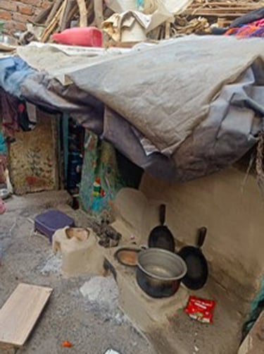Small Delhi slum home with cooking things outside.