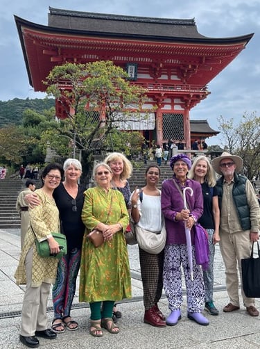 Eight people standing in front of a traditional Japanese building.