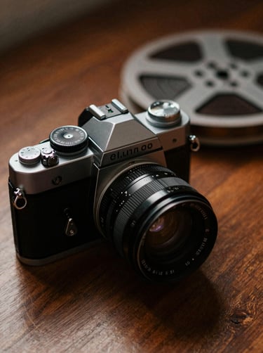 A cinematic close-up of a high-end vintage camera and film reels on a mahogany surface, lit with warm #8D765D tones and deep shadows, representing artistic depth.